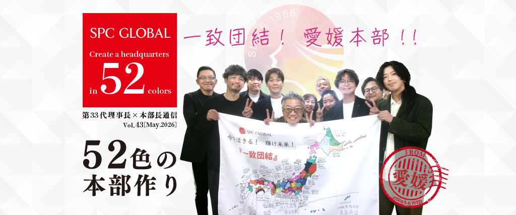 Group of people posing with a large banner showing a map and a red SPC GLOBAL logo on the left, celebrating a 52-color headquarters project against a patterned backdrop.