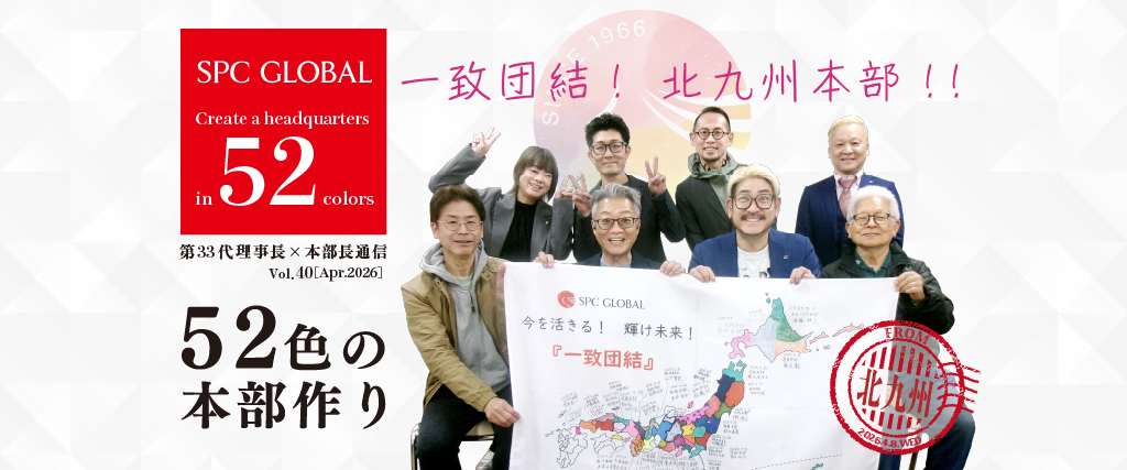 Group of people posing with a banner featuring a Japan map, promoting SPC GLOBAL’s slogan “Create a headquarters in 52 colors” with a red SPC GLOBAL logo.