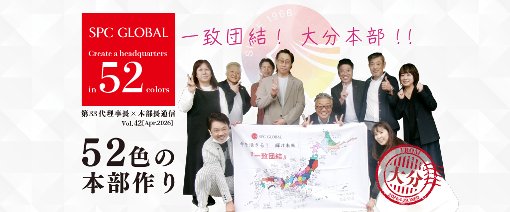 Group of coworkers posing in front of a banner with the SPC Global logo and a large map, promoting a '52 colors' headquarters project in Japan.